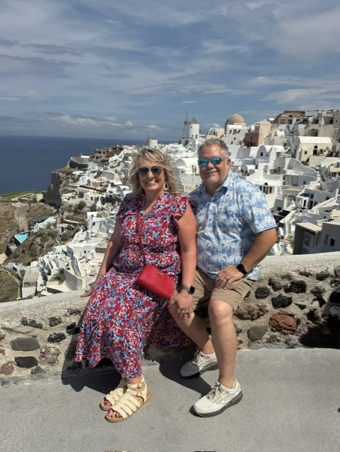 Cindy and Lee overlooking the whitewashed coastal buildings in Greece